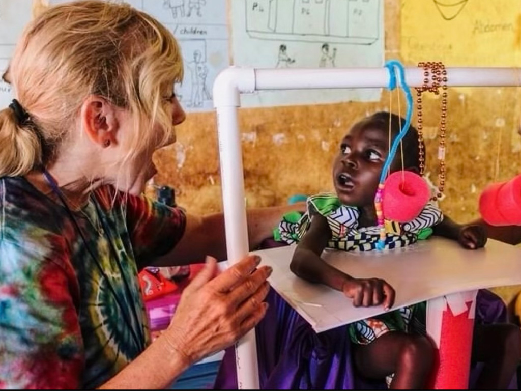 HPU OT Professor Patricia Coker-Bolt with a child in Uganda