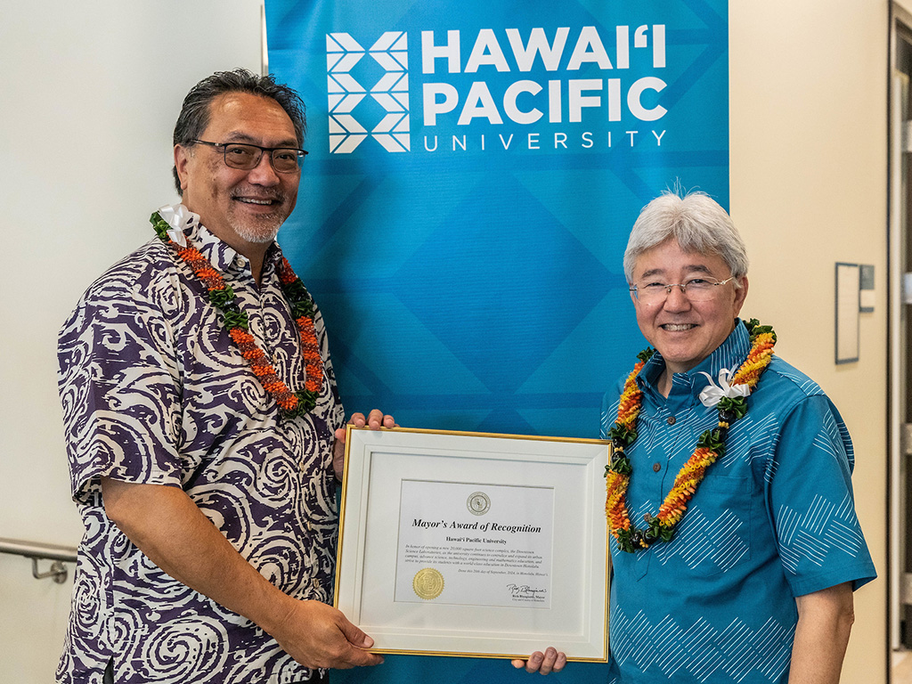 HPU Board Chair Lance Wilhelm (left) and HPU President John Gotanda (right) with the Award of Recognition from Honolulu Mayor Rick Blangiardi