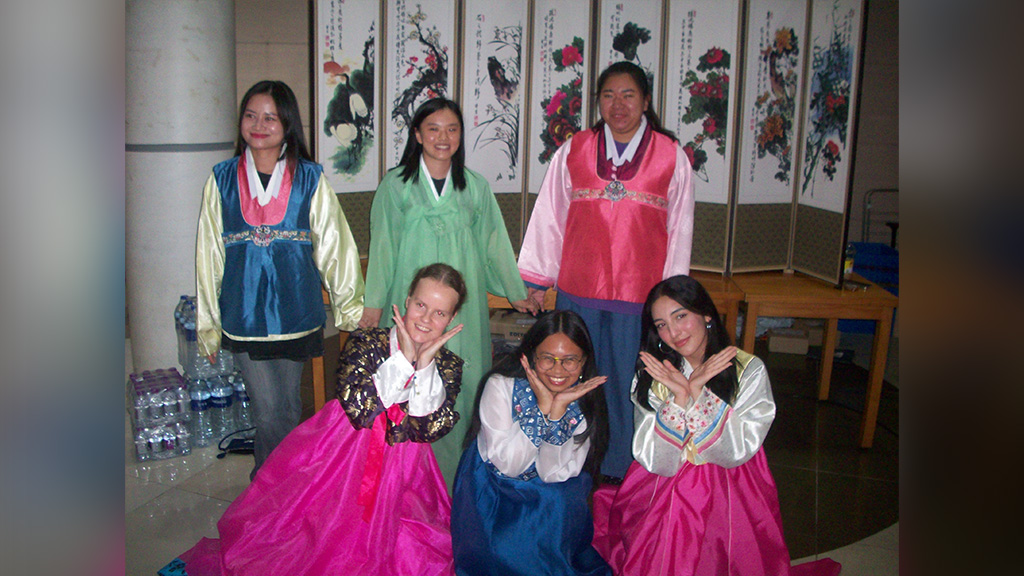 Reycajen Magbulos (front, center) and fellow students living in the Global Village campus dormitory, enjoy the Chuseok Coffee Hour event, meeting people, eating traditional Korean snacks like kkultteok (honey rice cake), and wearing hanbok (traditional Korean clothes)