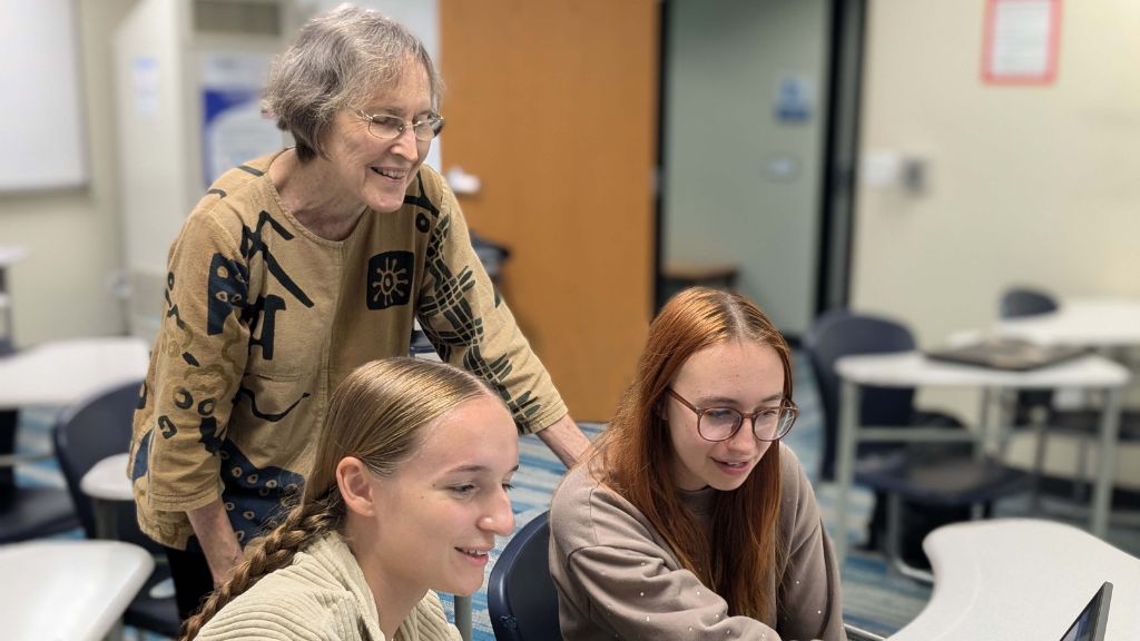 Instructor Jean Kirschenmann listens in as Camryn Potter and Haley Coppock enjoy the pathway stories of Oahu youth whose stories are now live on the GCV website