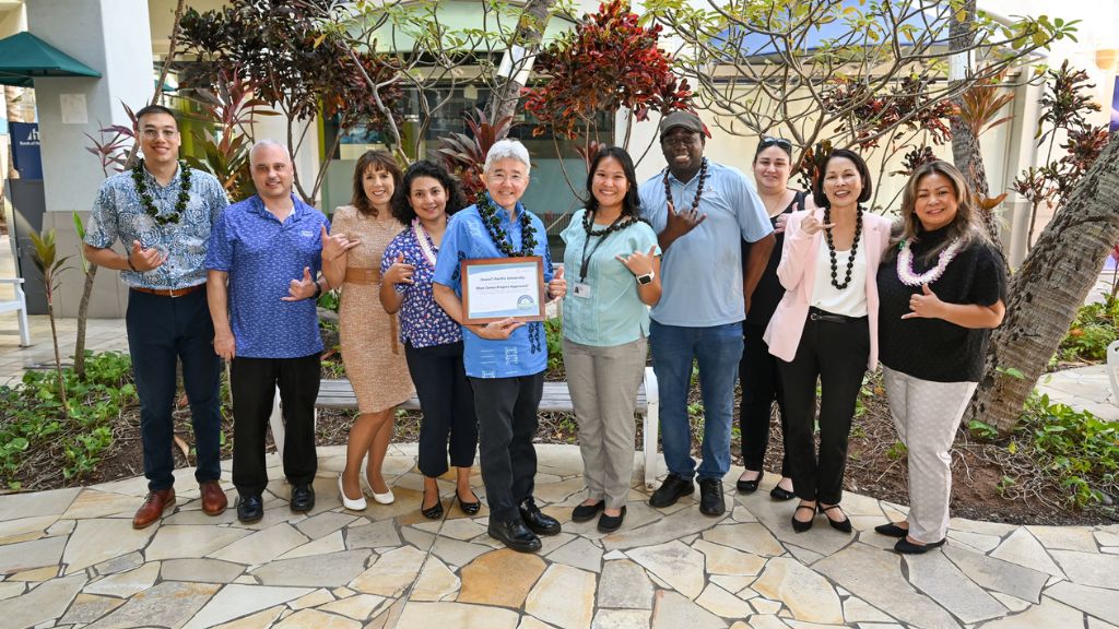 Cyrus Howe, far left, representing the Blue Zones Project in October 2023, with HPU administrators and staff, and Maricel Blackwell of HMSA, far right, at HPU's event at Aloha Tower Marketplace celebrating HPU as a 