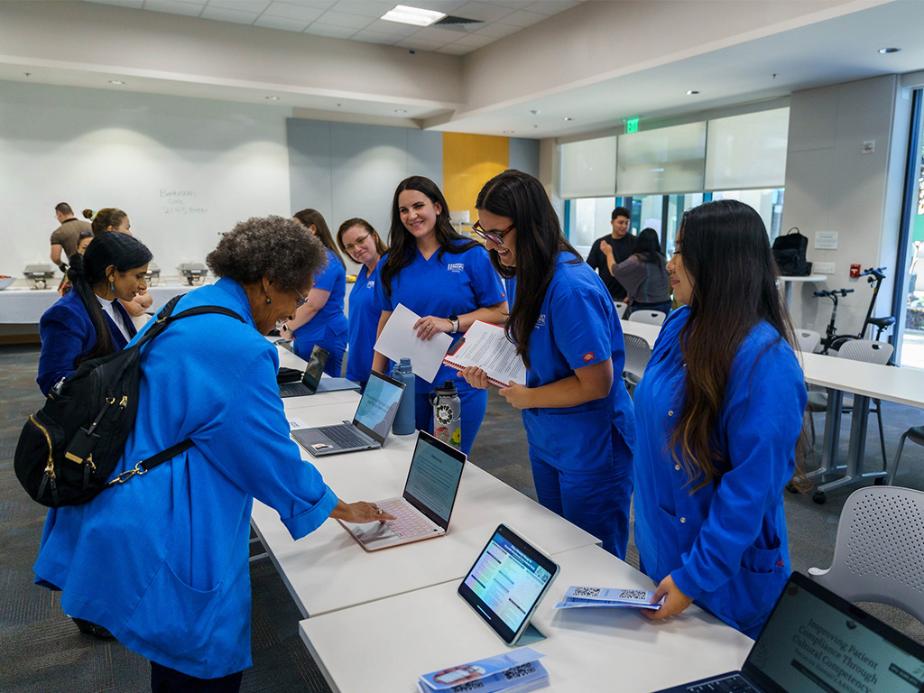 HPU Professor Patricia Burrell (left, at computer) was a judge at the event