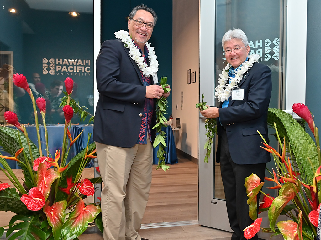 HPU President John Gotanda (right) and HPU Board Chair Lance Wilhelm (left) untying the maile lei at the HPU Las Vegas Campus grand opening event