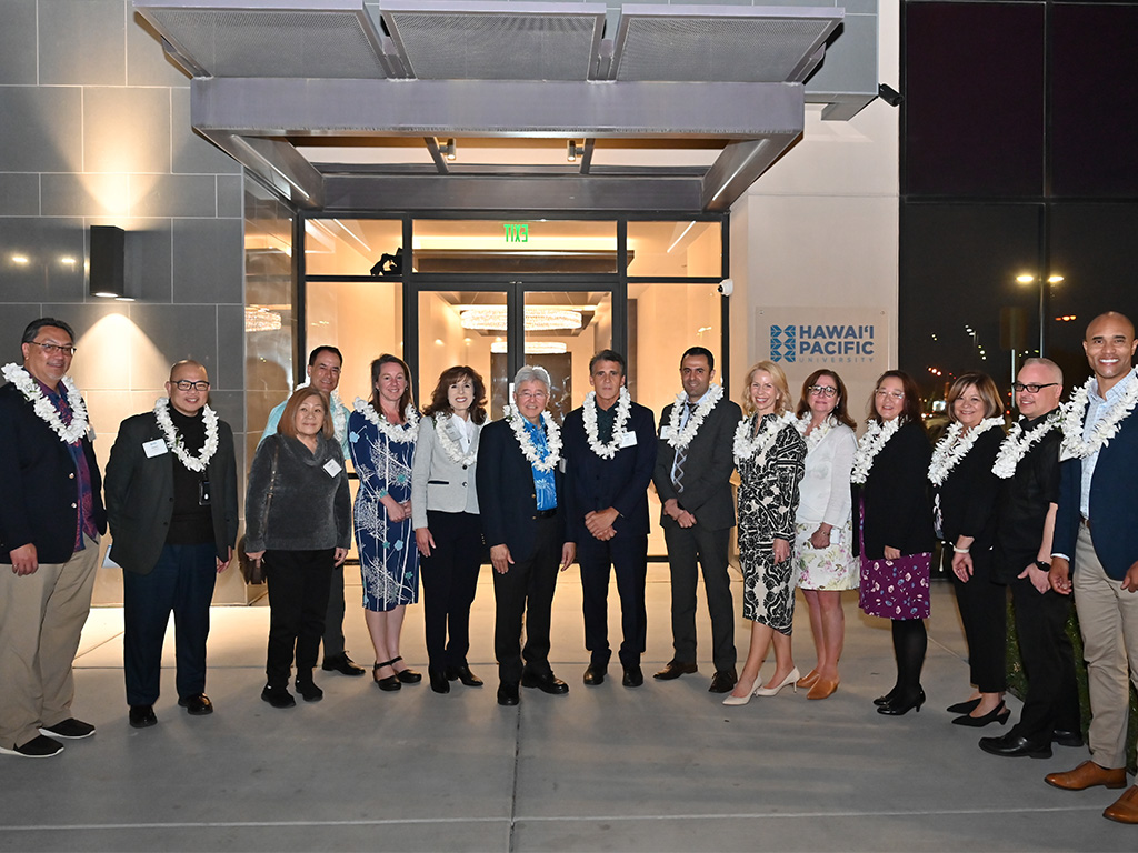 HPU leadership, faculty, and staff at the main entrance to the campus